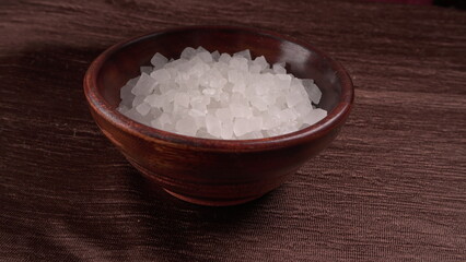 Wooden Spoon with white sugar on the dark background.
