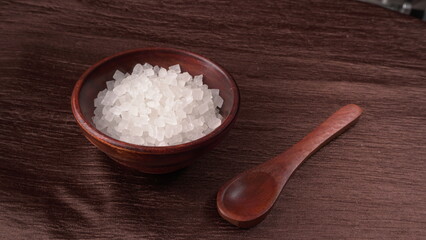 Wooden Spoon with white sugar on the dark background.
