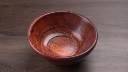 Empty wooden bowl and wooden spoon isolated with copy space.