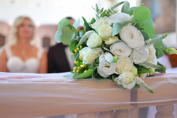 Wedding bouquet of white flowers on the railing of the kneeler in the church - 623445506