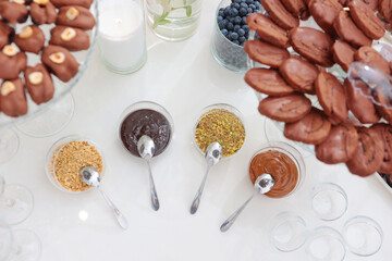 Assortment of sweet sauces. Various sauces and toppings for dishes. Desserts are on table. The concept of public catering.