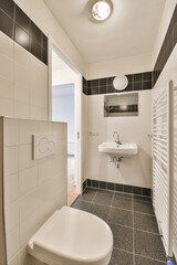 a small bathroom with black and white tiles on the walls, toilet and sink are visible in this image taken from above