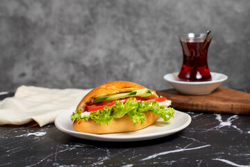 Sandwich with cheese, tomato, cucumber and lettuce. Delicious sandwich on dark background