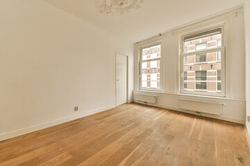 an empty room with wood flooring and white paint on the walls, there is a chandel in the corner
