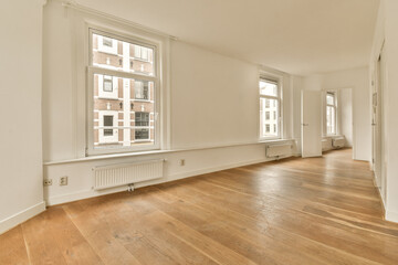 an empty room with wood flooring and large windows in the center of the room is white walls, wooden floors