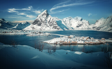 Scenic image of Norway nature in winter sunny day. Snowcapped mountains, perfect blue sky reflected in water north fjord. Impressively beautiful Scenery of Lofoten islands. Beauty of nature concept