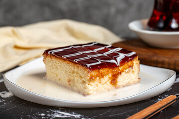 Trilece dessert with milk and caramel. Slice of caramel cake on dark background. Close up