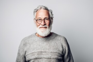 Obraz premium Environmental portrait photography of a glad old man wearing a cozy sweater against a pearl white background. With generative AI technology
