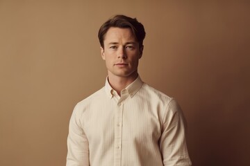 Obraz premium Medium shot portrait photography of a glad boy in his 30s wearing an elegant long-sleeve shirt against a warm taupe background. With generative AI technology