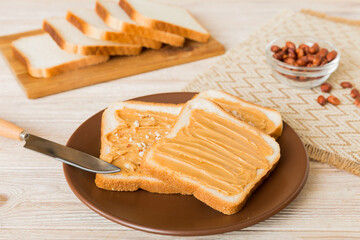 Fototapeta na wymiar Peanut butter sandwiches or toasts on light table background.Breakfast. Vegetarian food. American cuisine top view vith copy space