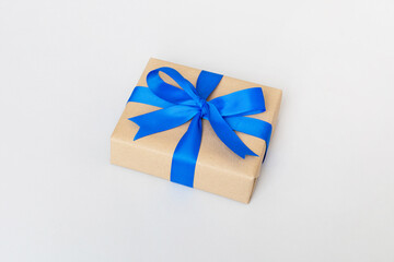 Wrapped christmas or other holiday handmade present in craft paper with colored ribbon. Present box, decoration of gift on table, top view with copy space