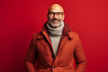 Lifestyle portrait photography of a satisfied mature man wearing a cozy winter coat against a ruby red background. With generative AI technology