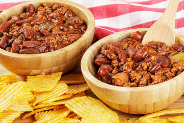 A wooden bowl of delicious Chili with Cheddar Cheese