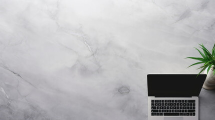 A laptop sits on an empty marble tabletop