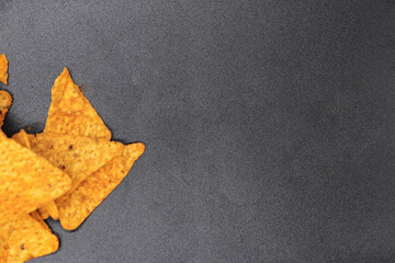 mexican nachos in a bowl on black background with copy space