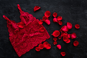 Elegant red lace lingerie bikini panties with rose petals, top view
