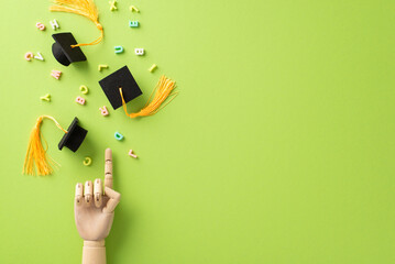 Graduation from high school concept on this vibrant picture featuring wooden hand pointing on mini...