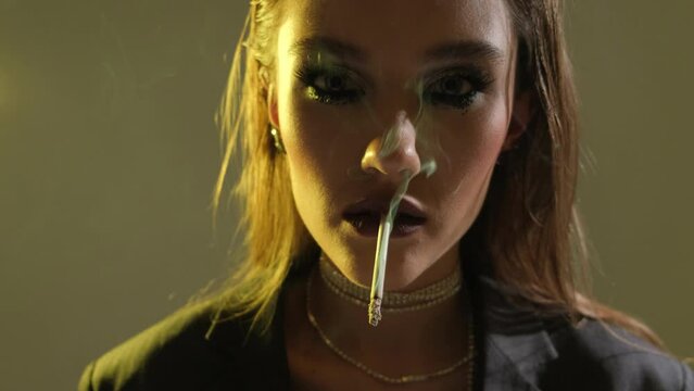 Fashion art portrait of beauty model woman in bright lights with colorful smoke. Smoking girl in neon light