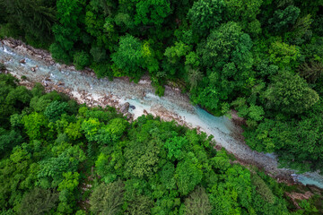 Soca river in Slovenia. Aerial drone top down view of emerald green river in forest