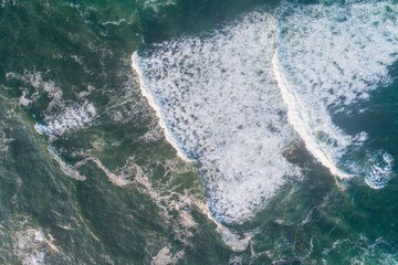 Fototapeta na wymiar Aerial view of the foam crashing waves on shore