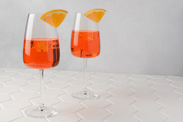 Aperol spritz cold summer cocktail with aperitif, prosecco, ice and slice of orange in a glass on...