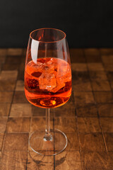 Aperol spritz cold summer cocktail with aperitif, prosecco, ice and in a glass on the black background. Copy space for text