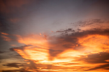 Obraz premium Glowing gold, orange-red, cloudy sky at sunset. Wallpaper concept.
