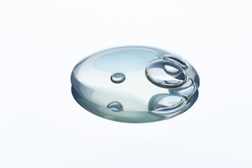 A drop of clear gel with bubbles. On a white background. With reflection in the mirror