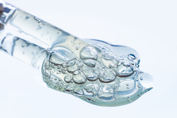 Spilled transparent bubbly gel in close-up. Leaking out of the pipette.