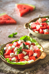 Fresh watermelon salad with feta cheese and mint on beige textured background