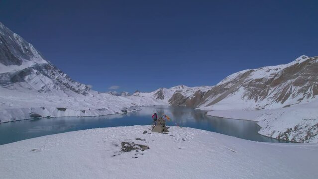 Aerial revealing view inspirational solo male trekker stand admire mountains. Reaching Tilicho lake in Nepal.Travel adventure lifestyle, Tilicho viewpoint, Himalayas.