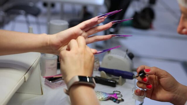 The process of nail extension in a beauty salon.