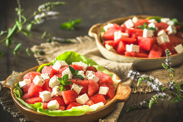 Fresh watermelon salad with feta cheese and mint on rustic wooden background