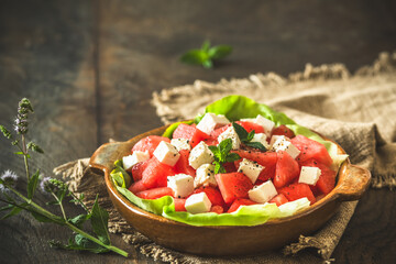 Fresh watermelon salad with feta cheese and mint on rustic wooden background