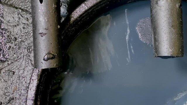 Black chemical wastewater coming out from pipe to storage tank from industrial processes. Hazardous and toxic waste - WWTP Wastewater Treatment Procedure