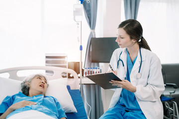 Obraz premium Friendly nurse taking care of elderly woman in a hospital room. Treatment of patients.