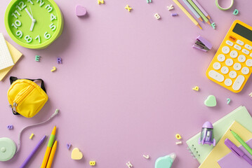 Step into the realm of education with this compelling top-down photograph featuring notepad and a variety of school supplies on isolated light purple background. Ideal copy-space for text or adverts