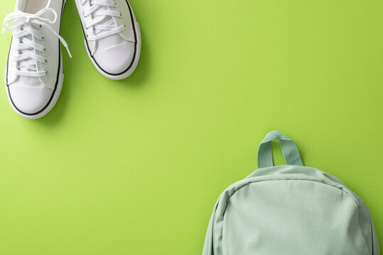 Engage Your Audience With This Visually Pleasing Top View Image Showcasing A Backpack And Pair Of White Sneakers On A Light Green Isolated Background. Great For Educational Campaigns And Advertising