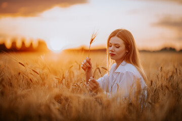 A woman admires the sunset while holding a corn stalk