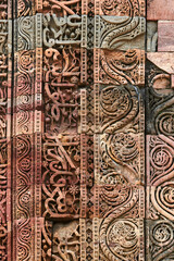 Wall decorative patterns of Qutb complex in South Delhi, India, close up ancient bas relief wall decorations of mosque ruins landmark, popular touristic spot in New Delhi, ancient indian architecture