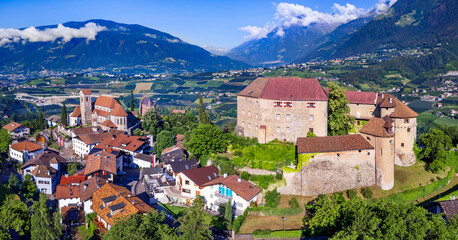 Tourism of northern Italy.  Traditional picturesque mountain village Schenna (Scena) near Merano town in Trentino - Alto Adige region. view of medieval castle, aerial view - obrazy, fototapety, plakaty