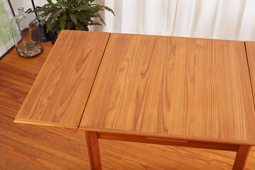 Vintage draw leaf table. Mid-century modern teak furniture. View from above with open leaves.