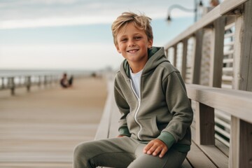 Lifestyle portrait photography of a glad kid male wearing a comfortable tracksuit against a picturesque beach boardwalk background. With generative AI technology