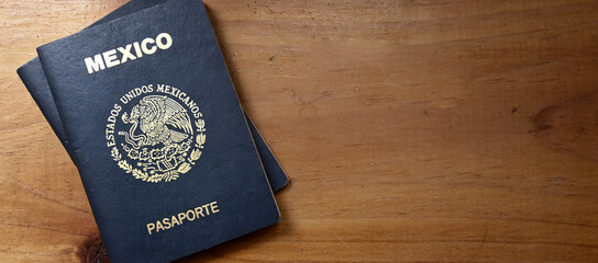 Bird's-eye view of two Mexican passports on a wooden table, copy space.