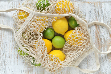 Bright yellow lemons & green limes in an Eco-friendly, low waste, reusable string bag tote