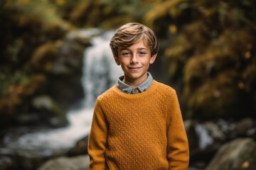 Editorial portrait photography of a joyful kid male wearing a cozy sweater against a picturesque waterfall background. With generative AI technology