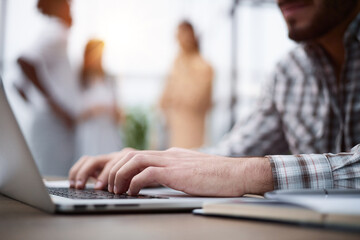 Side view shot of businessman working by using a laptop computer on table.