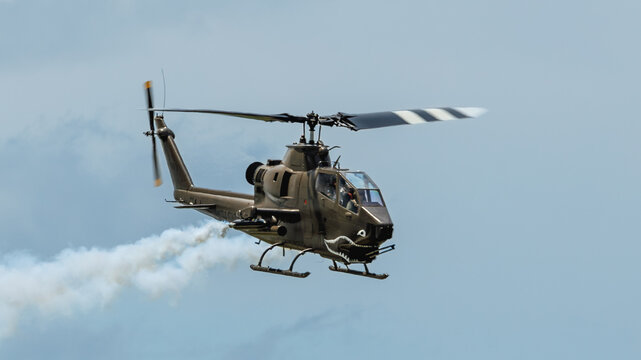 Cobra helicopter approaches from the left with smoke trailing