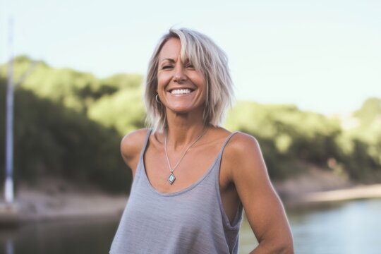 Casual fashion portrait photography of a joyful mature girl wearing a daring bikini against a peaceful riverside walk background. With generative AI technology