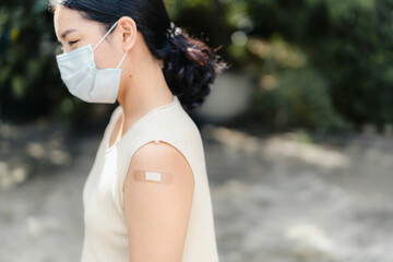 Healthy asian young teenager woman wear face mask with bandage after get covid-19 vaccine, Herd...